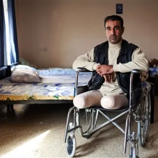 Un hombre que perdió las dos piernas sendado en una silla de ruedas.