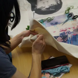 una persona bordando las telas para la exhibición 