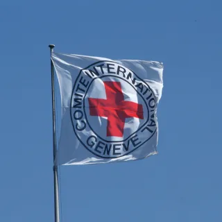 Bandera del CICR ondea frente a un cielo azul