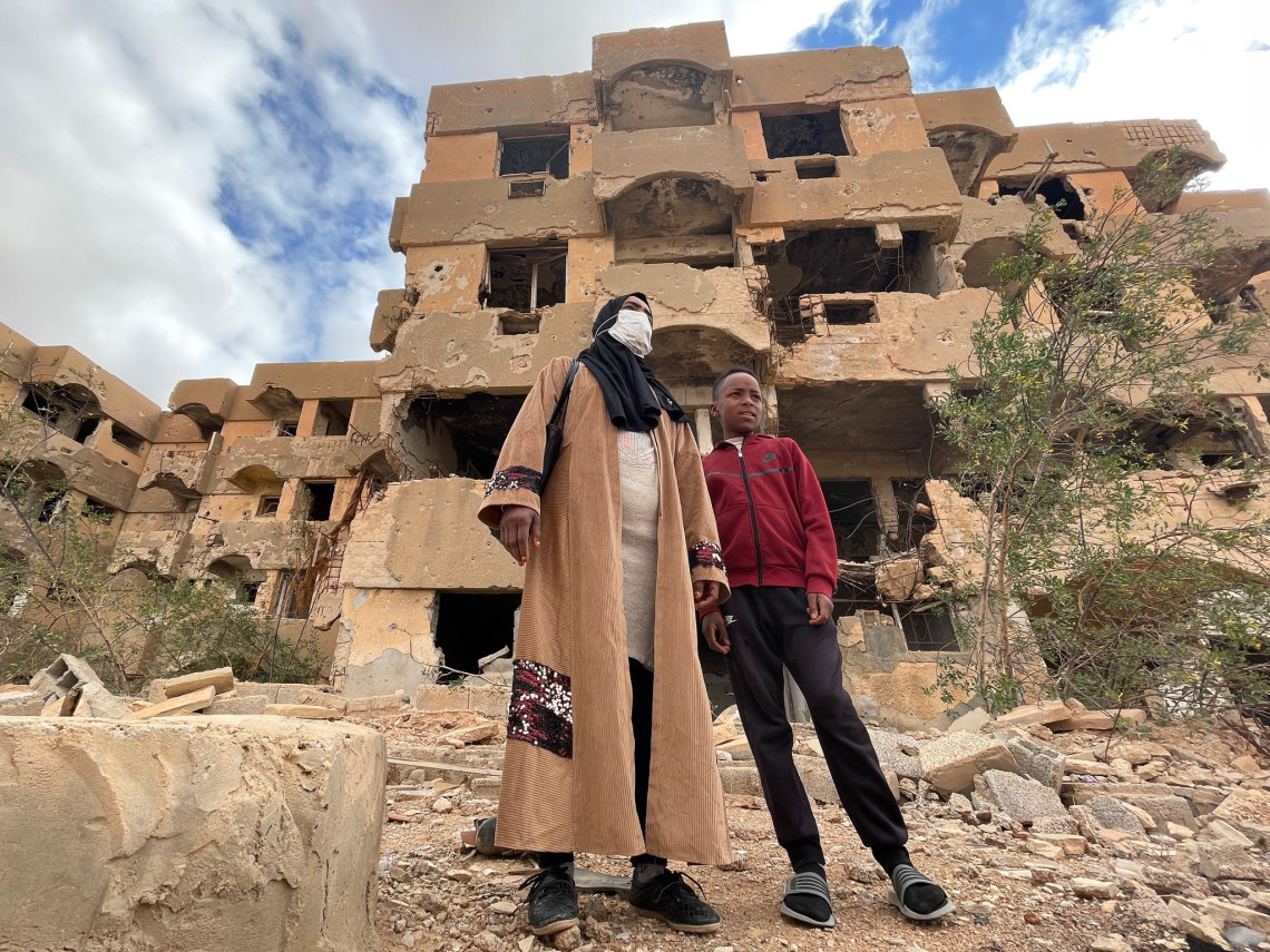 Mariam et son fils devant leur immeuble à Tawergha, Libye. Hussein Elyaser / CICR