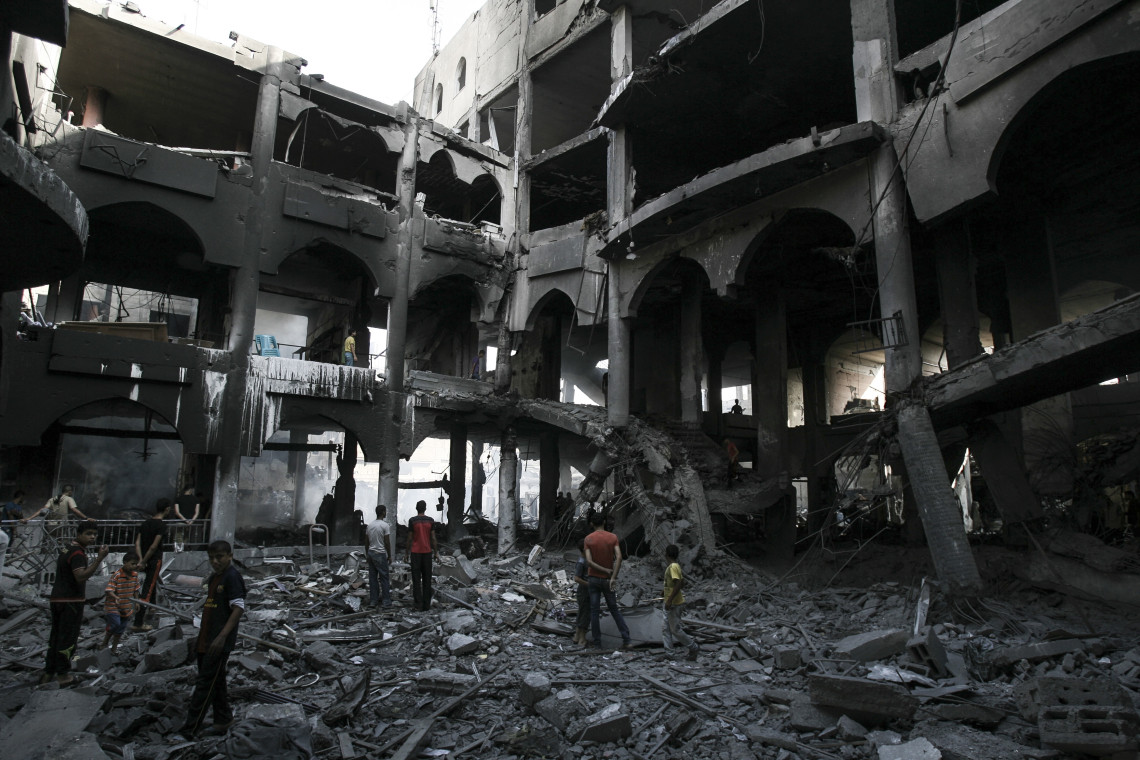 在加沙拉法，平民在被轰炸破坏的大商场前。 © ICRC