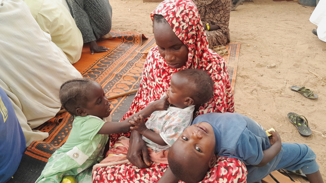 2023年4月29日，乍得，库弗伦（Koufroun），一名逃离暴力局势的苏丹难民带着孩子与其他难民聚集在苏丹和乍得边境附近。REUTERS/Mahamat Ramadane