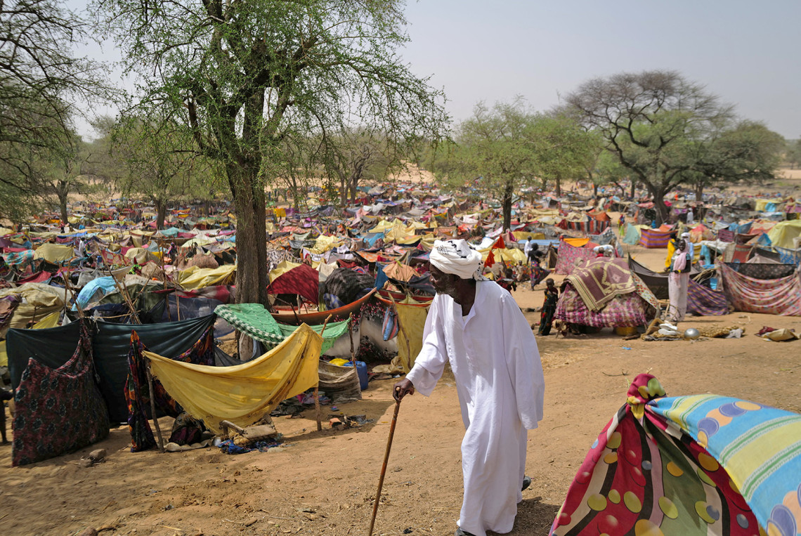 Un homme soudanais qui a fui le conflit dans la région soudanaise du Darfour, et qui était auparavant déplacé à l'intérieur du Soudan, passe devant des abris de fortune près de la frontière entre le Soudan et le Tchad, alors qu'il se réfugie à Borota, au Tchad, le 13 mai 2023. REUTERS/Zohra Bensemra