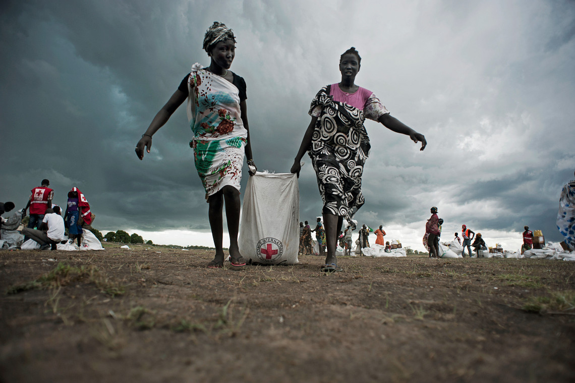 Mujeres recogiendo sorgo y aceite unas horas después de un lanzamiento aéreo realizado por el CICR en el estado de Unity, Sudán del Sur - 2014. Jacob Zocherman/ CICR.