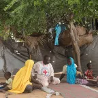 Two women who fled Nigeria and sought refuge in Chad speak with an ICRC employee about their living conditions in the refugee camp.