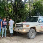 Trabajadora de CICR en diálogo con dos personas.