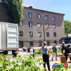 ICRC trucks with a yellow car and people in the foreground