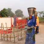 Une bénéficiaire devant le forage construit.