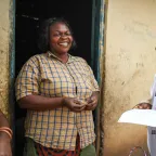 ICRC delegate speaking to a smiling woman in a doorway