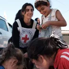 Kids at the shelter playing with an ICRC worker