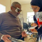 Rajaa Ewaidah practices the use of his new wheelchair with ICRC physiotherapist Saeda Albarawi at Al Amal Hospital in Khan Younis. Rajaa lost his legs due to a severe injury from an airstrike. Ahmed Al Waheidi / ICRC 