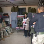 Una trabajadora del CICR explica el DIH a personal militar en un cuarto de tropa.