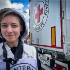 An ICRC worker standing in front of a marked truck