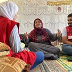 ICRC staff in Aleppo with a woman sitting on the ground