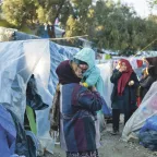 Lesbos, Moria, Olive Grove informal camp. A woman holds a baby in her arms.