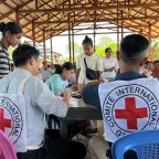 Two ICRC staff assisting people in Myanmar