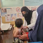 An Afghan Red Crescent Society (ARCS) healthcare worker examining a patient at an ARCS's clinic in Kabul