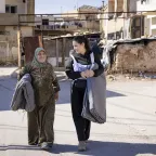 A staff member talks to a beneficiary during a distribution of aid items