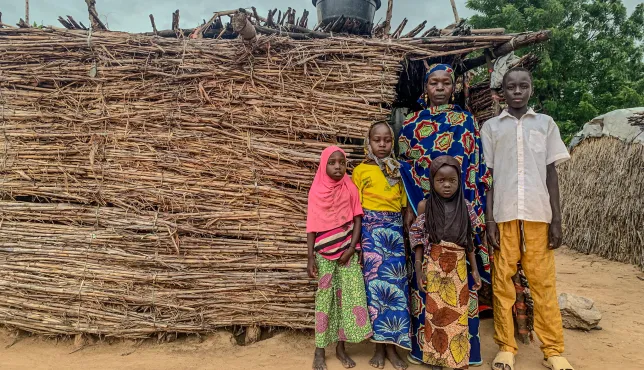Fana Biri posing in front of her home with her children