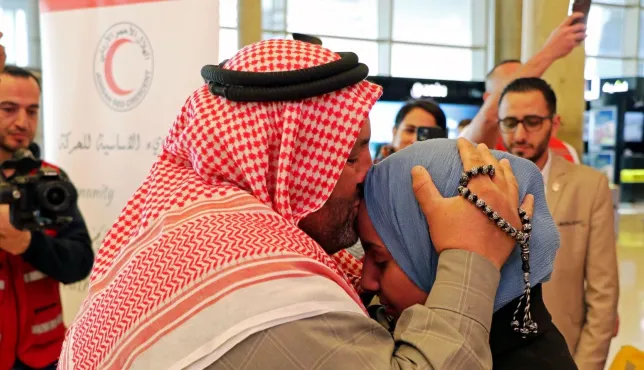 A Syrian refugee takes his missing daughter in his arms and kisses her on the forehead