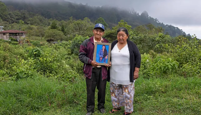 Un hombre y una mujer sostienen la fotografía de un familiar desaparecido.