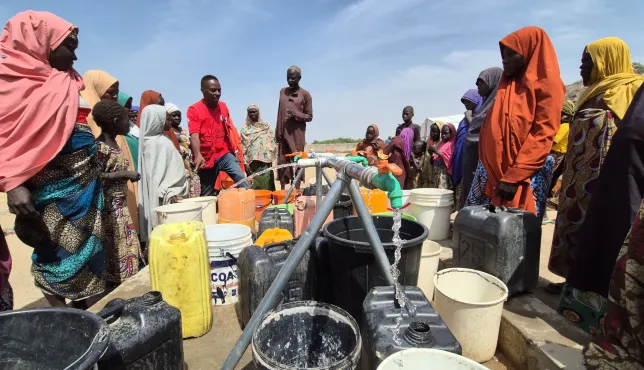 Community water point with community members fetching water