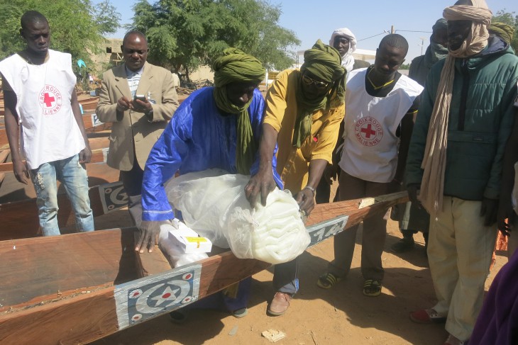 A fisherman loads his nets and hooks onto the boat he has received from the ICRC.