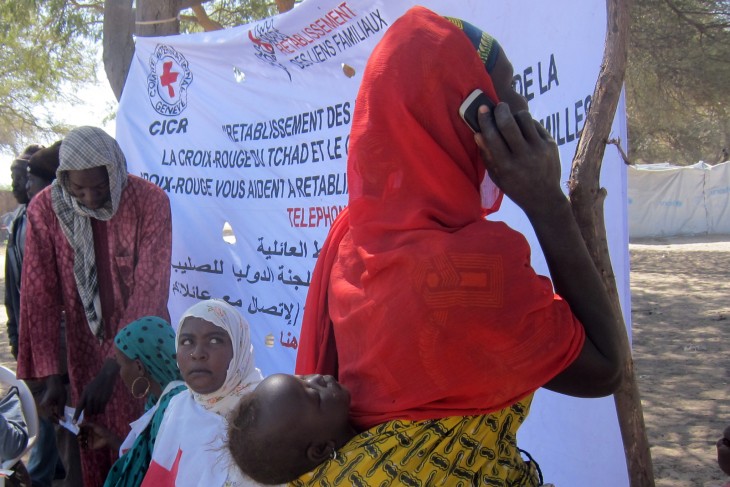 A Nigerian woman who has fled across the border into Chad makes use of an ICRC phone to contact her family. 