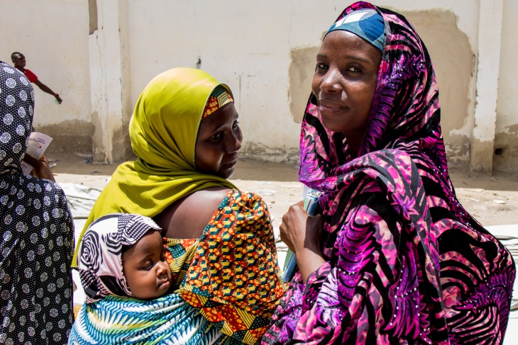 Displaced women and a baby at an ICRC aid distribution in Maiduguri, Nigeria. 