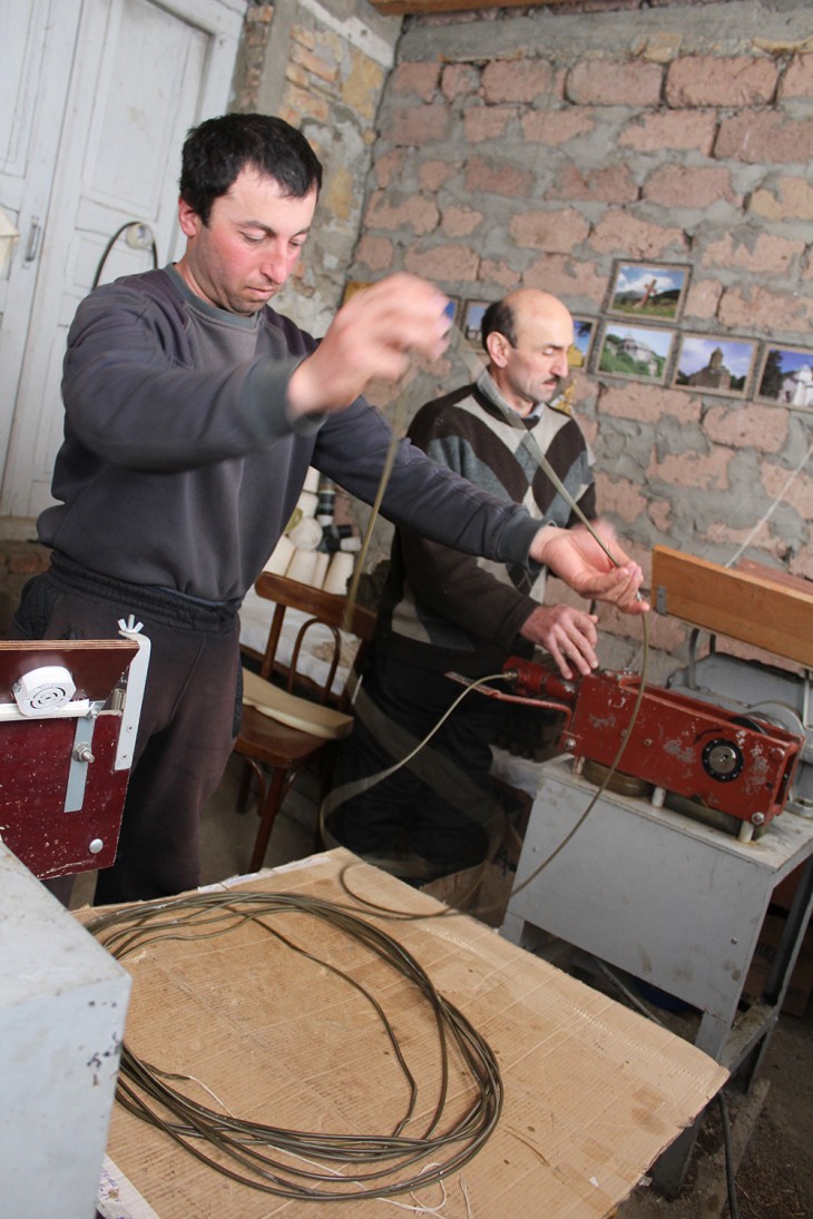 Monaster, South Ossetia. Avtandil (on the left) prepares the wick for his candles.