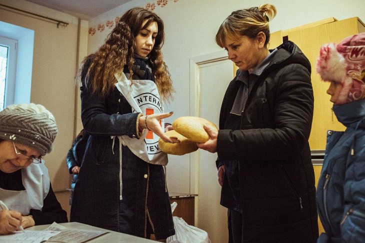 Ukraine. A mother displaced by the fighting collects food for her family.