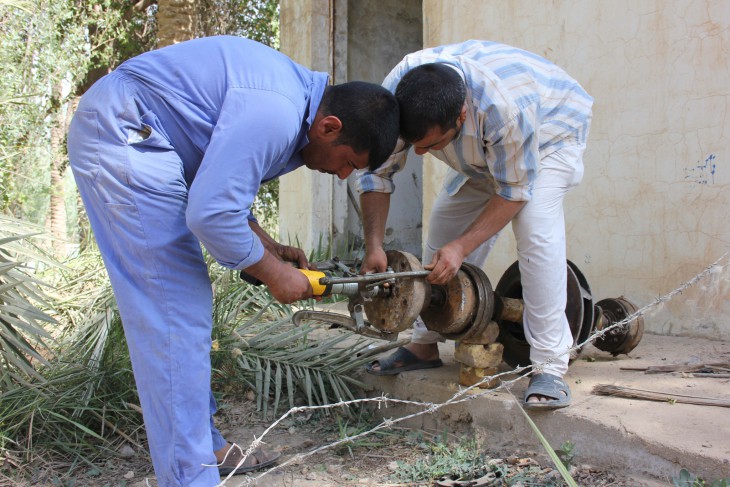 Al-Barakiya, near Abu Aissa, southern Iraq. An operator repairs a water pump at the water treatment plant supplying the village.