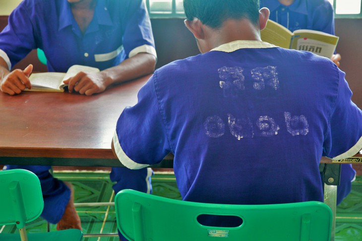 Detainees read in a prison library.