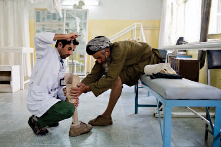 An ICRC orthopaedic technician adjusts a prosthetic leg.