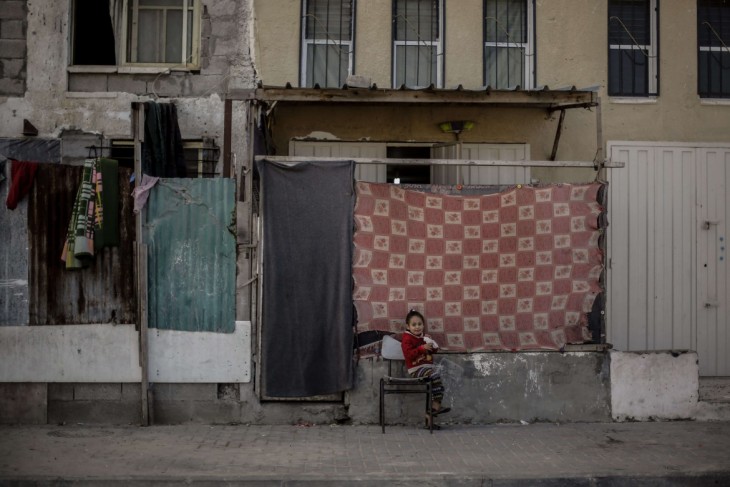 El conflicto palestino-israelí. Una niña sentada frente a su casa, ubicada en las torres Al-Nada, en el norte de Gaza. CC BY-NC-ND / CICR / Mohammed Talatene