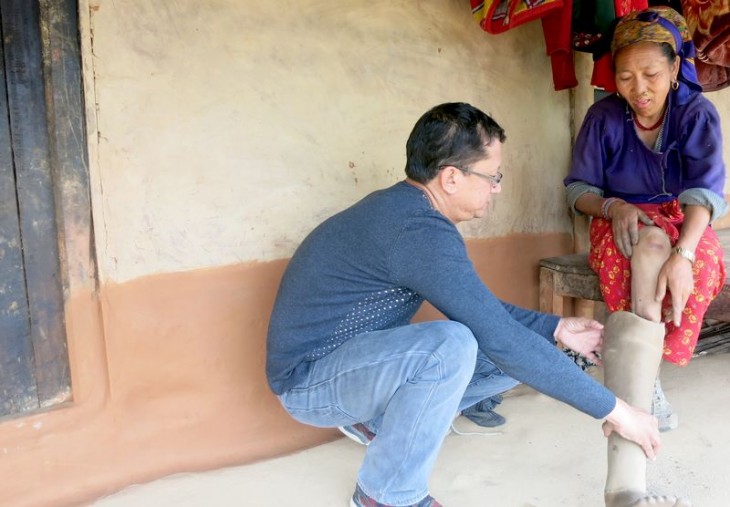 Jagadish Shrestha, health programme responsible at the ICRC Kathmandu inspecting the prosthesis. ©Binod Kafle, ICRC